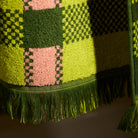 Detail shot of a green, lime and pink plaid hand towel showing woven terry texture and green fringe edge