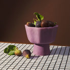 Pink Joy Pedestal Bowl filled with fresh figs on checkered surface showing functional use