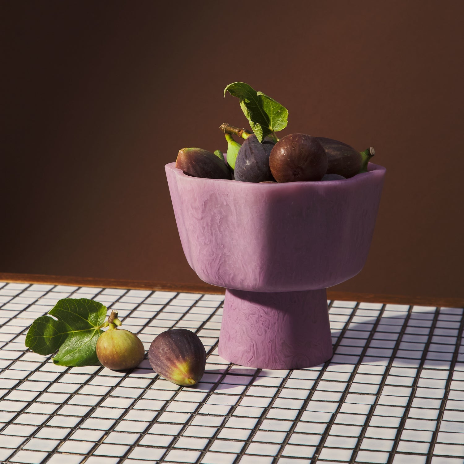Pink Joy Pedestal Bowl filled with fresh figs on checkered surface showing functional use