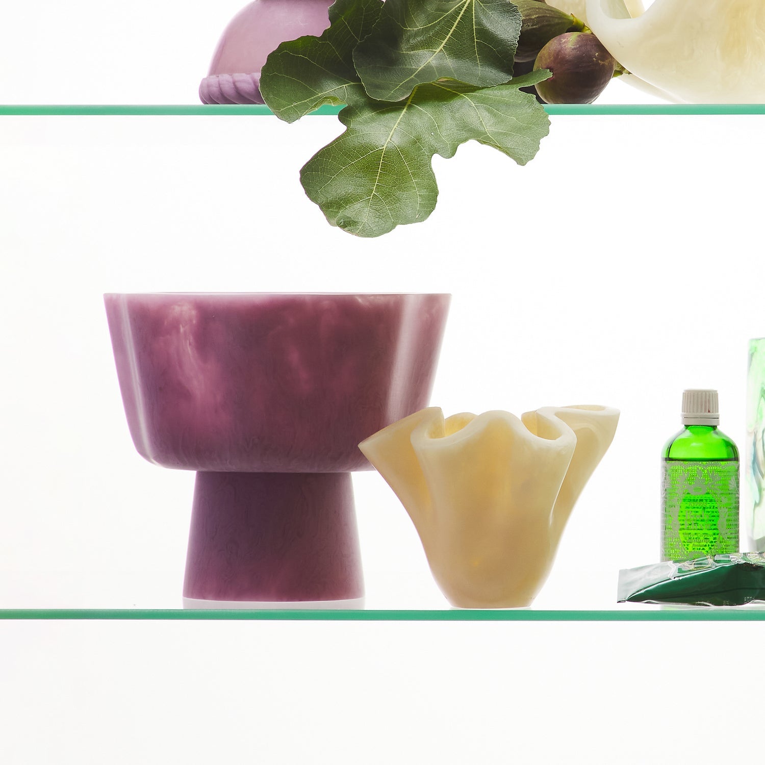 Side view of pink Joy Pedestal Bowl on glass shelf with cream bowl showing size comparison