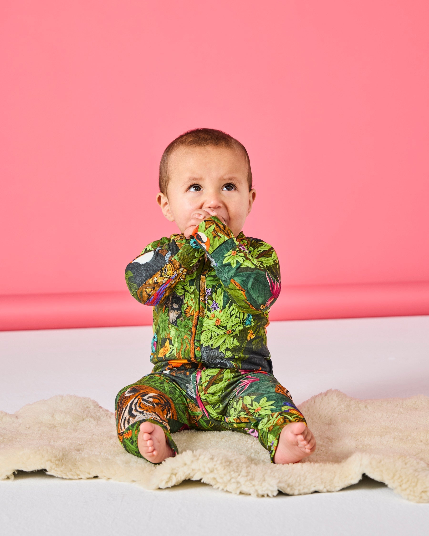 Baby wearing Jungle Life organic cotton romper during playtime on soft blanket