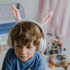 White Kidyears bluetooth headphones with bunny ears worn by child in playroom
