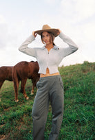 Woman wearing stone grey Kaia Zip Cardigan showing fitted ribbed hem and zip closure