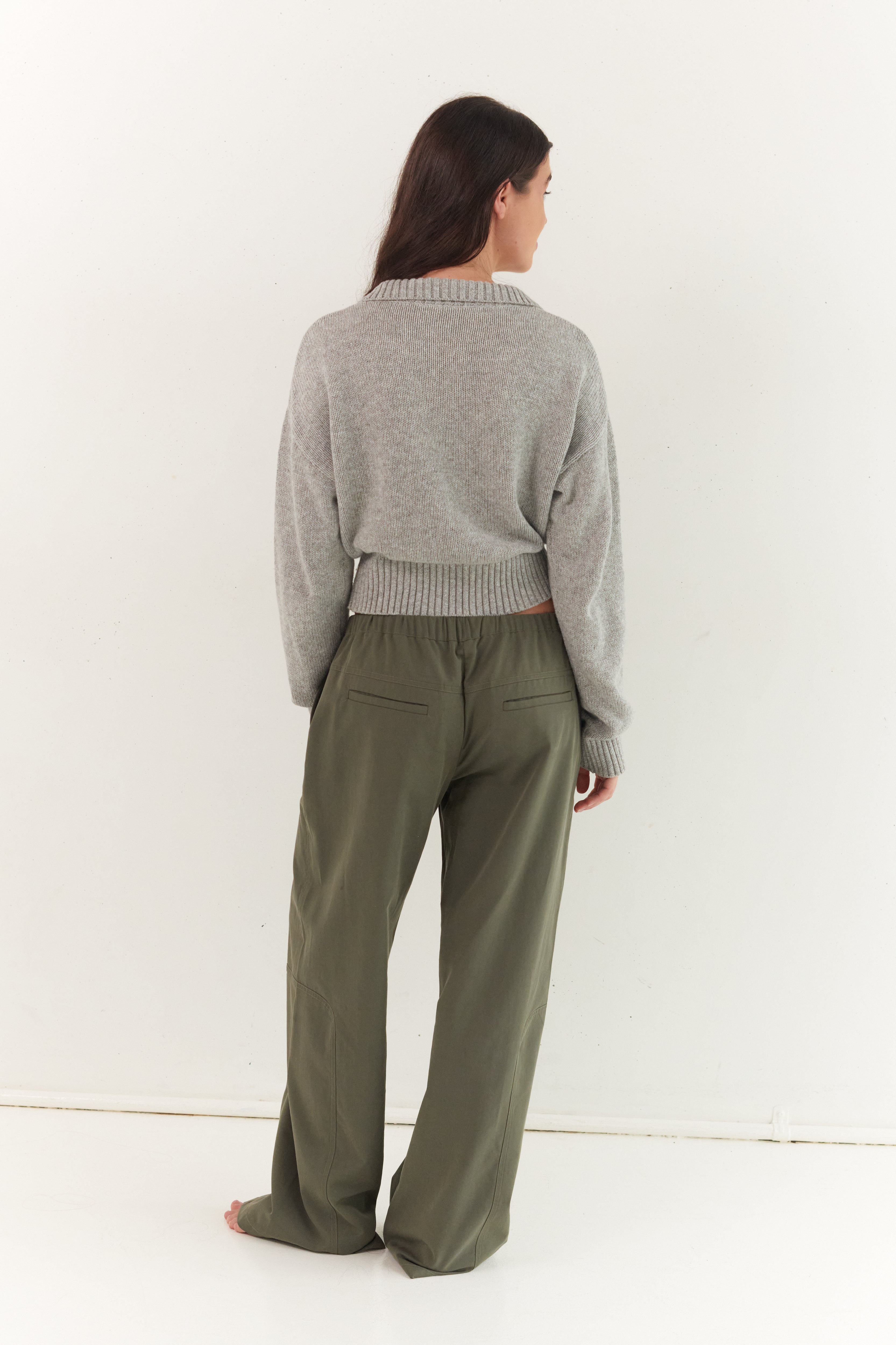 Back view of stone grey Kaia Zip Cardigan showing ribbed collar and cropped silhouette