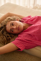 model laying down wearing the Kaitlyn Shirt Raspberry pink Stripe by Kireina