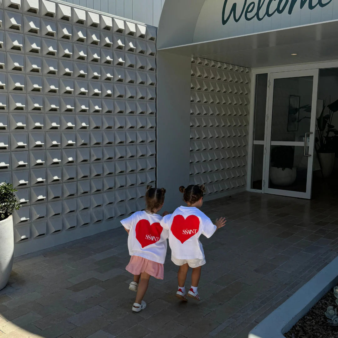 two girls wearing Ssaint tshirts with red heart graphic