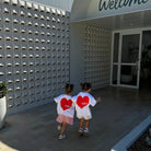two girls wearing Ssaint tshirts with red heart graphic
