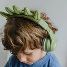 Child wearing Kidyears dinosaur headphones by Kidywolf