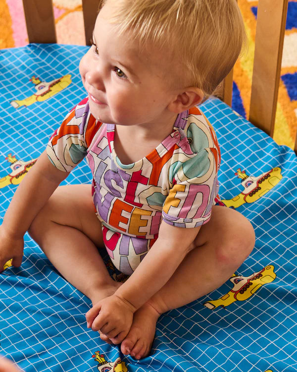 Baby wearing colourful "All you need is love" Kip & Co onesie