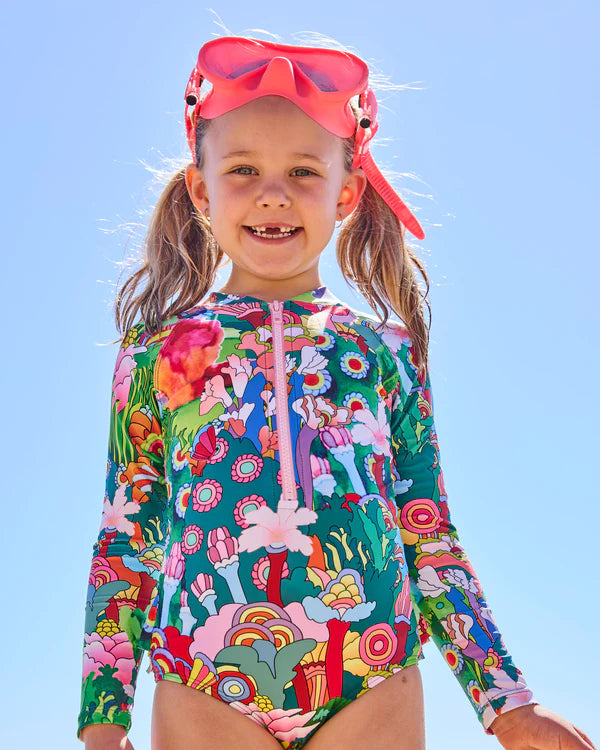 girl wearing Kip & Co x The Beatles Big Flower Dreamscape Long Sleeve Bathers