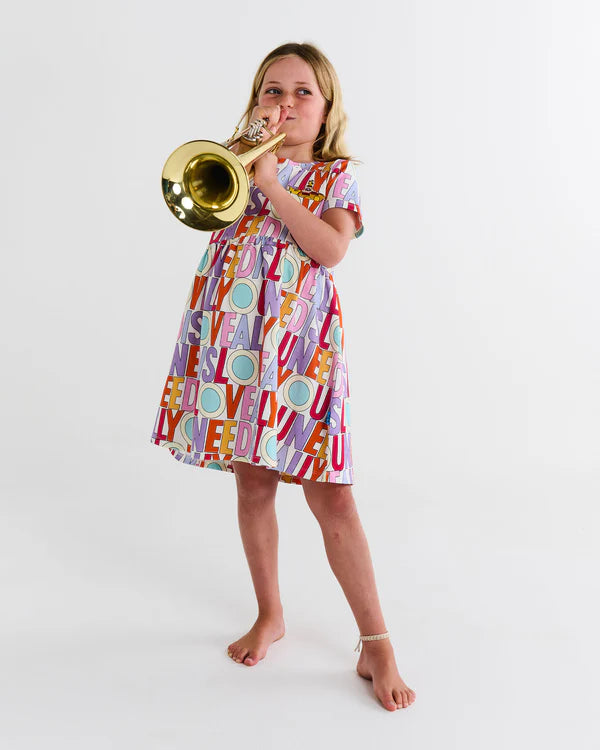 Girl wearing Kip&Co x The Beatles All You Need Is Love Organic Cotton Everyday Dress