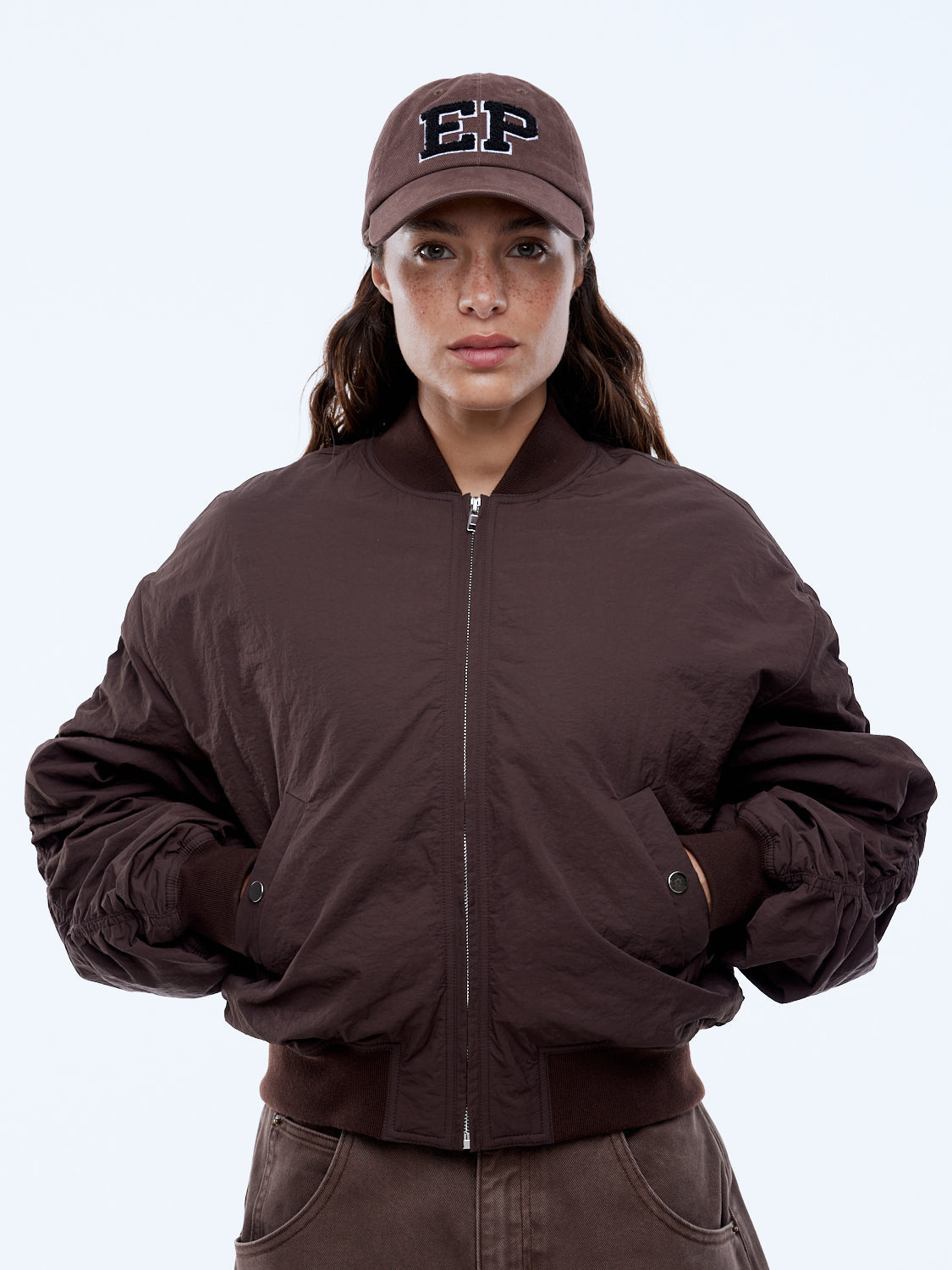 Model wearing Ena Pelly Lulu Bomber mocha puffer jacket lifestyle outdoor urban setting