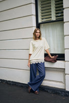 Full body styling of Lacey Tee in marshmallow cream paired with wide leg jeans