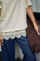 Close up detail of Lacey Tee lace hem trim against marshmallow cream fabric