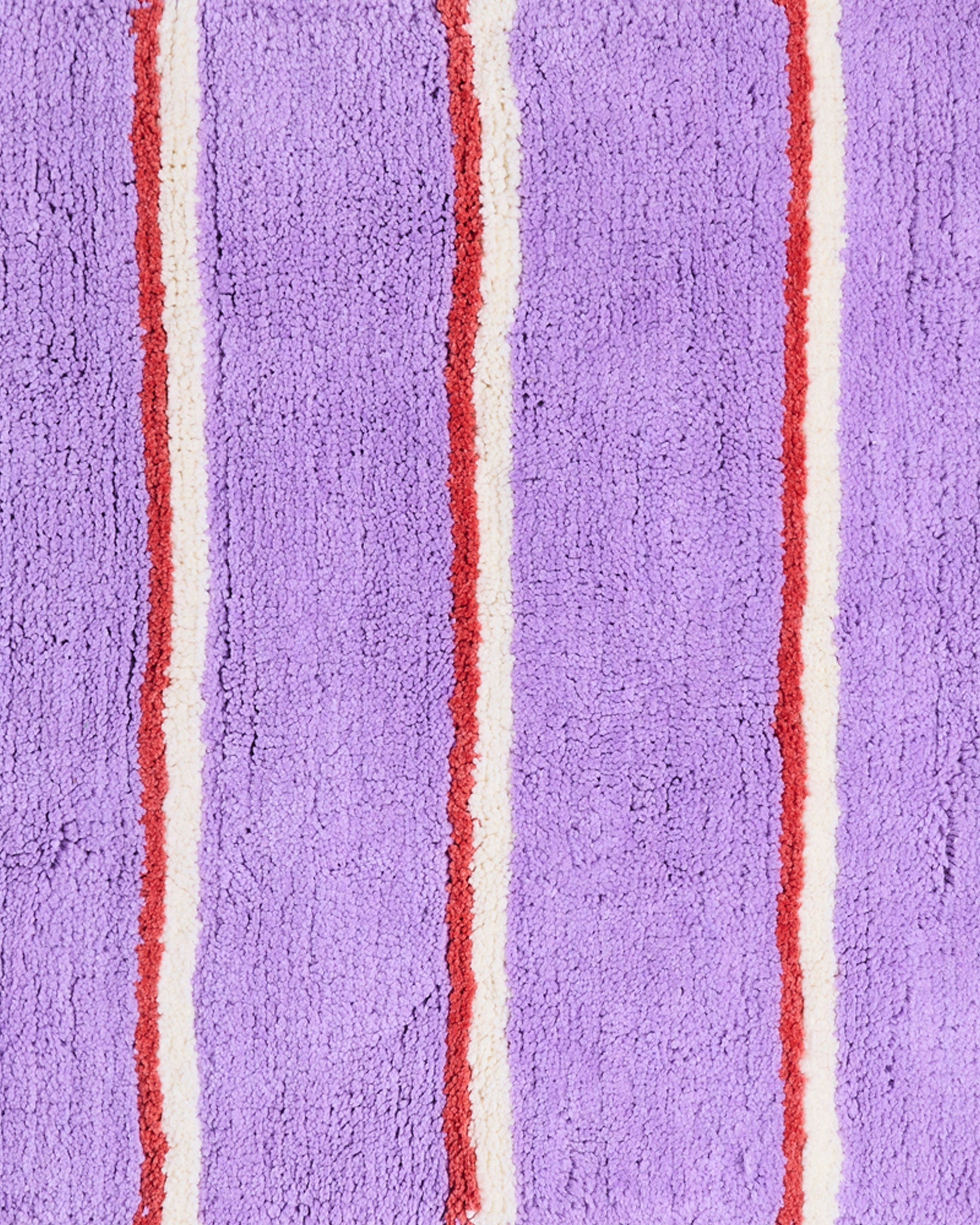 Close-up detail of lavender purple terry cloth fabric with red and cream vertical stripe pattern texture