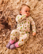 Baby wearing lilac booties with pink knit socks on soft textured blanket surface