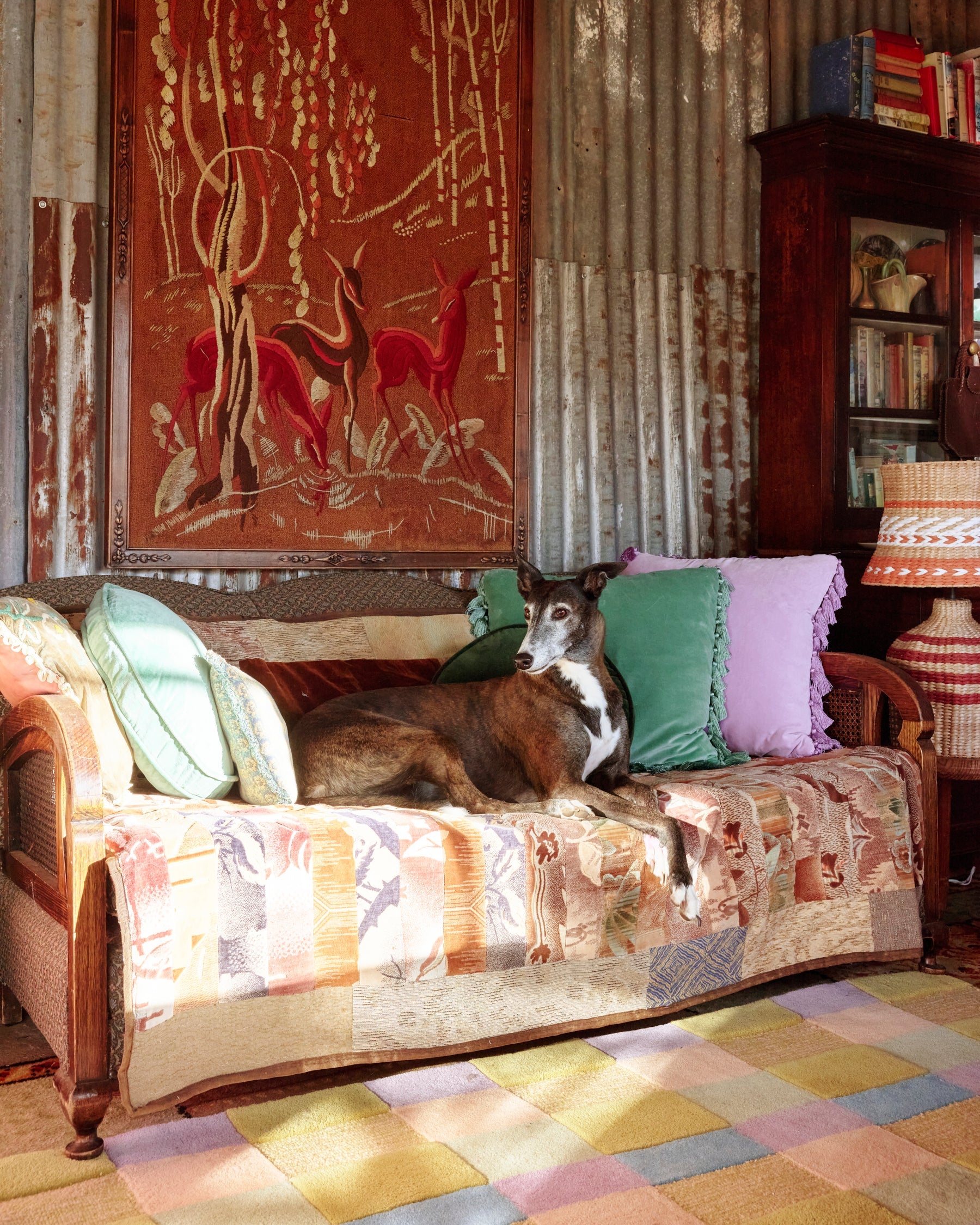 Rustic living room scene featuring lilac and green velvet tassel cushions on vintage sofa