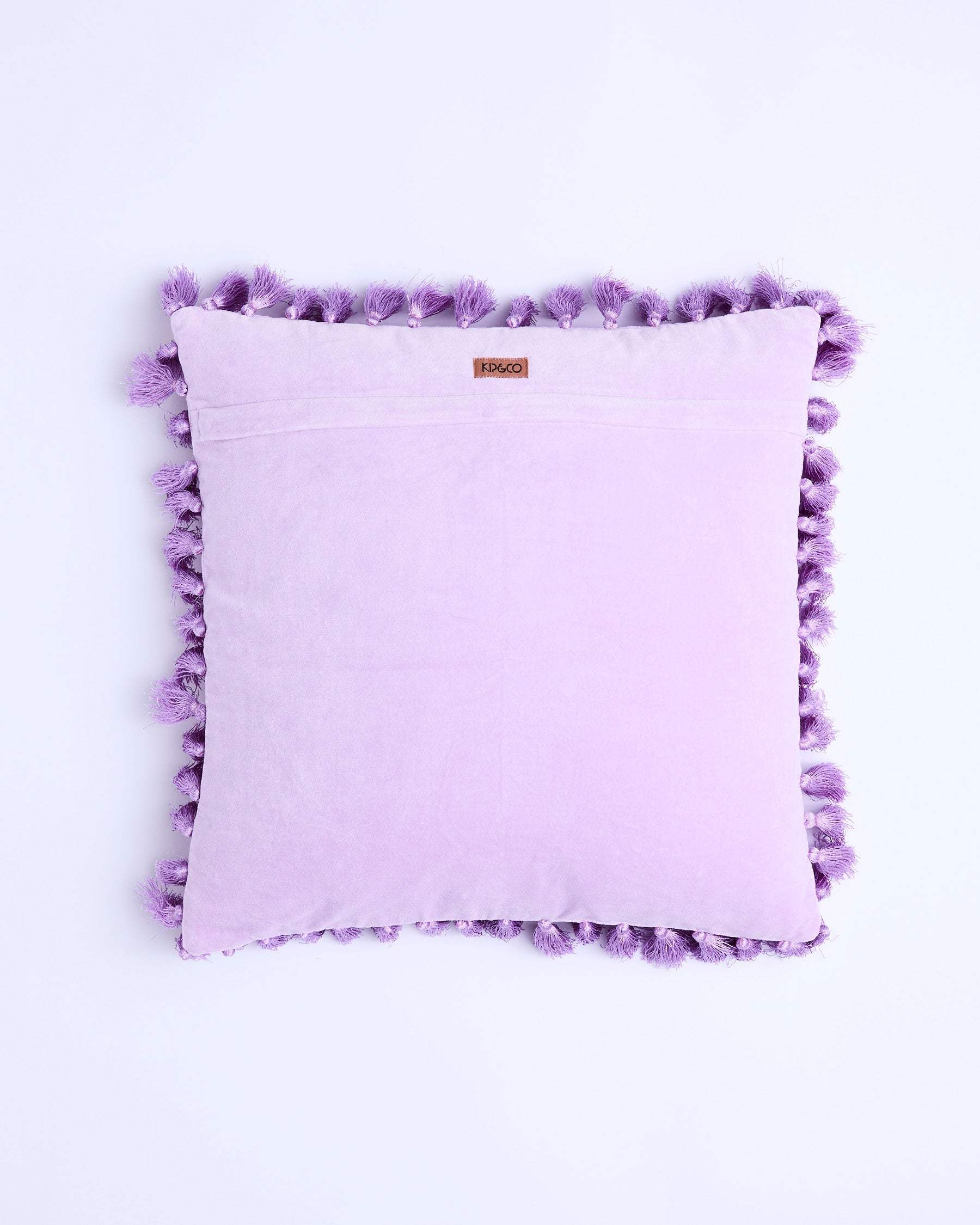 Back view of lilac velvet cushion showing smooth fabric and purple tassel border detail