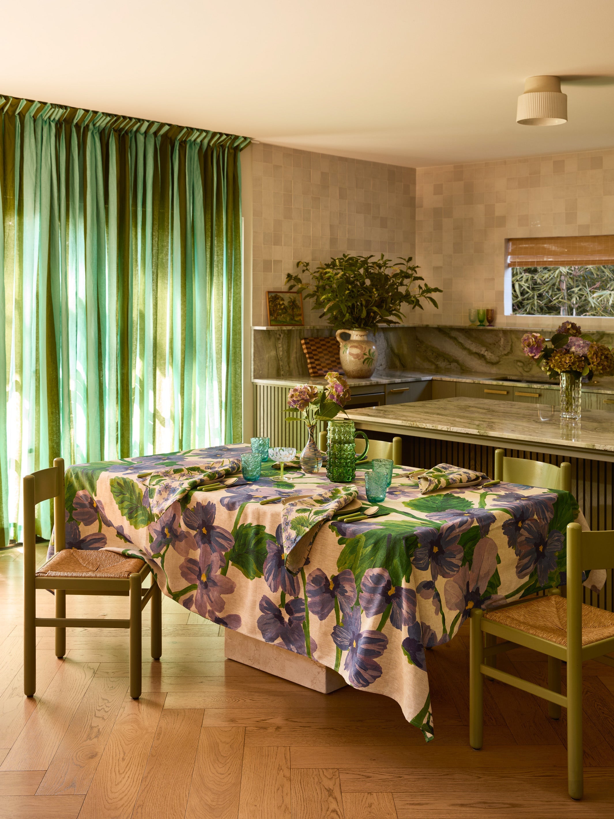 Kitchen dining area featuring Lilas Blue napkins with purple flower print on linen tablecloth