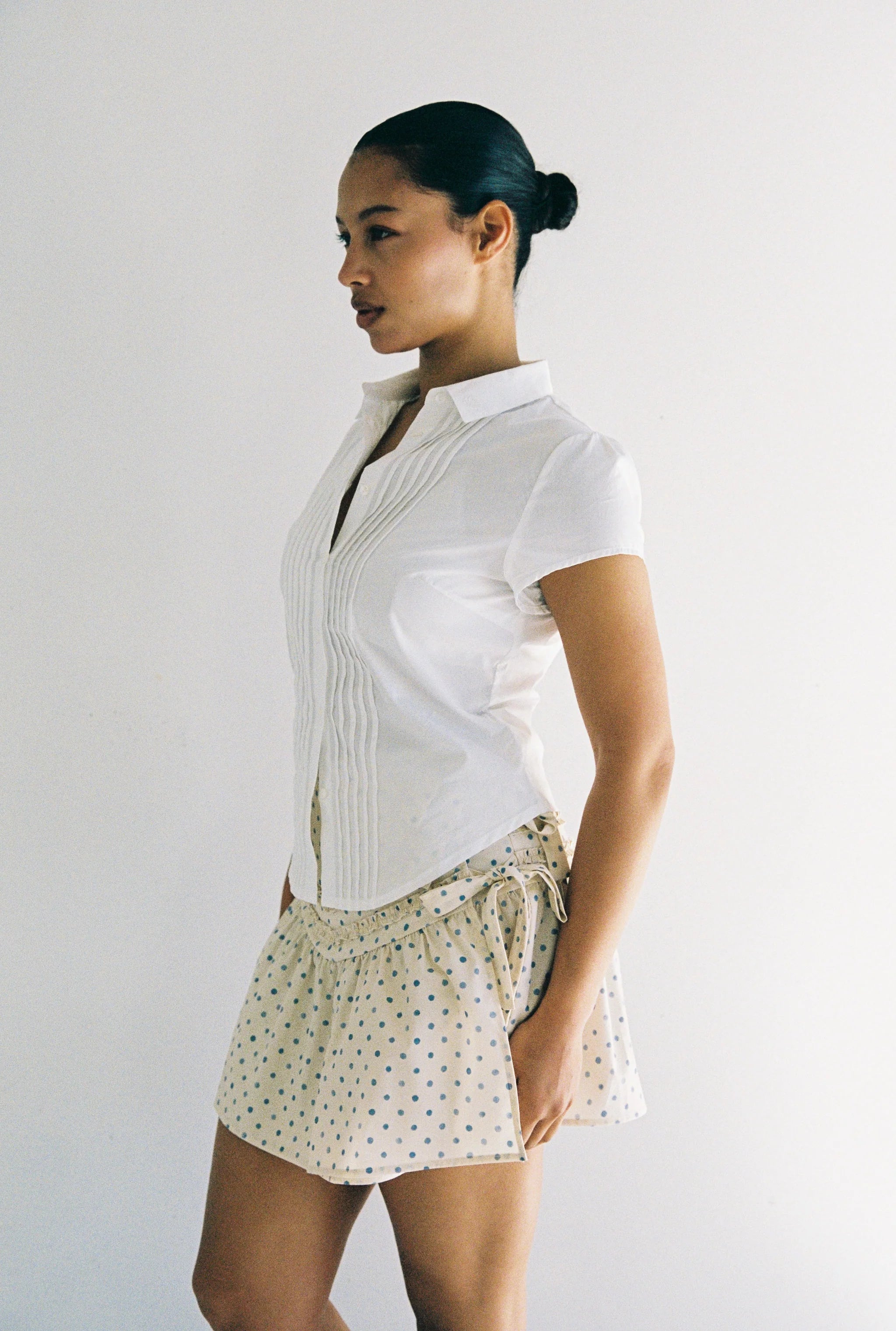 women wearing button down white cotton shirt with pintucking feacture and cap sleeves