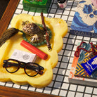 Close-up angled view of yellow resin tray with scalloped rim showing marbled texture and stored items