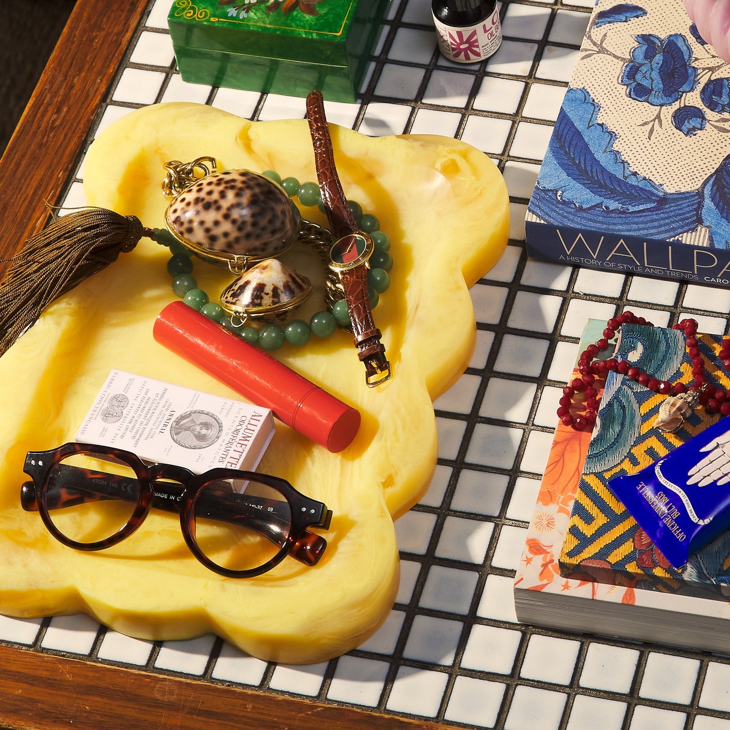 Aspen Gold marbled resin scalloped tray styled on a mosaic tile table with accessories and books