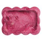 Crimson pink marbled resin tray with scalloped edges, overhead close-up of rectangular well