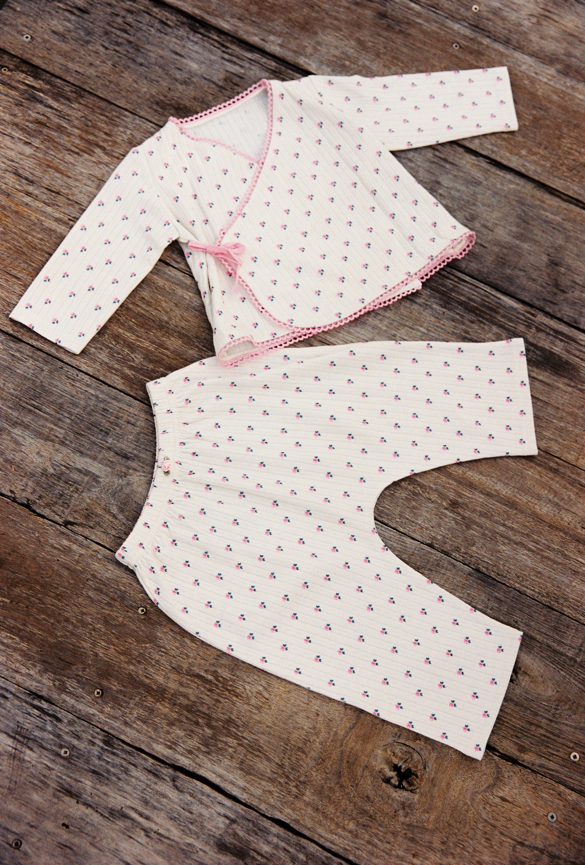 Flat lay of Lolly Set pajama pieces showing roses pattern and pink trim detailing
