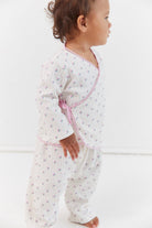 Side profile of child in Lolly Set pajamas with roses print and wrap tie detail