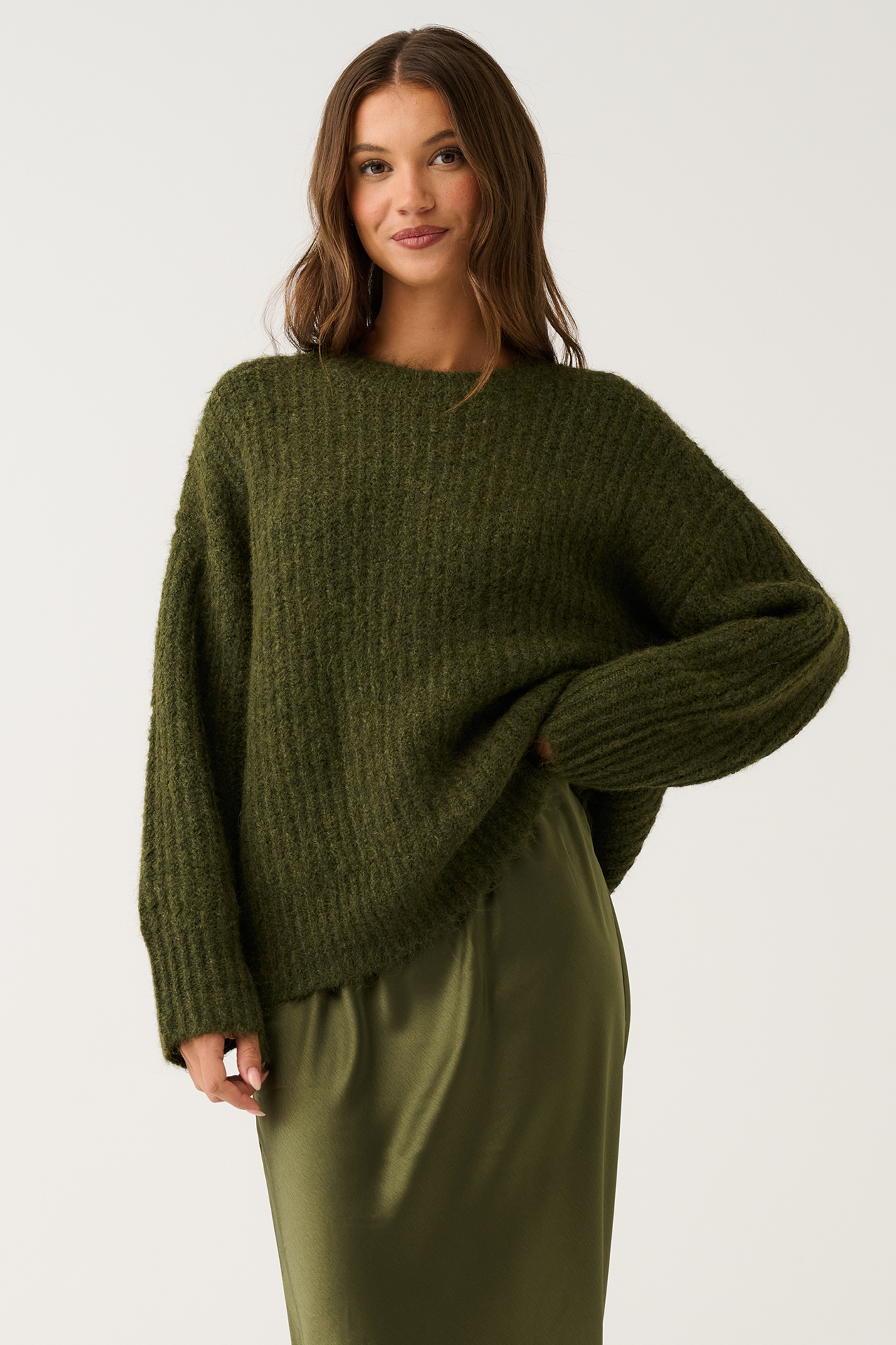 Three-quarter front view of an olive green oversized ribbed knit sweater with relaxed long sleeves and round neckline