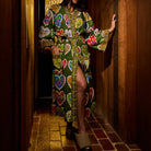 Full-length front view of a green cotton robe with multicolour floral heart print, tied belt, and open hem, worn by a woman