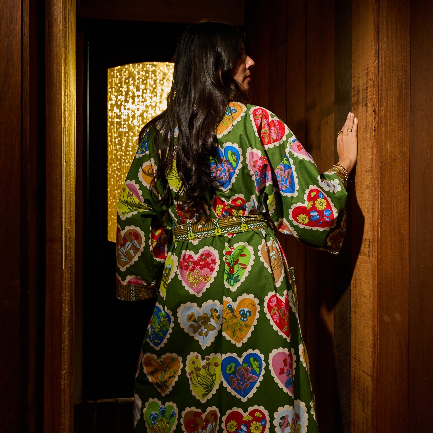 Back view of a green cotton robe with vibrant multicolour floral heart print, belted waist, and wide sleeves
