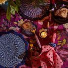 Orchid twisted-handle bottle opener laid in a vibrant boho tablescape with woven placemats and napkins