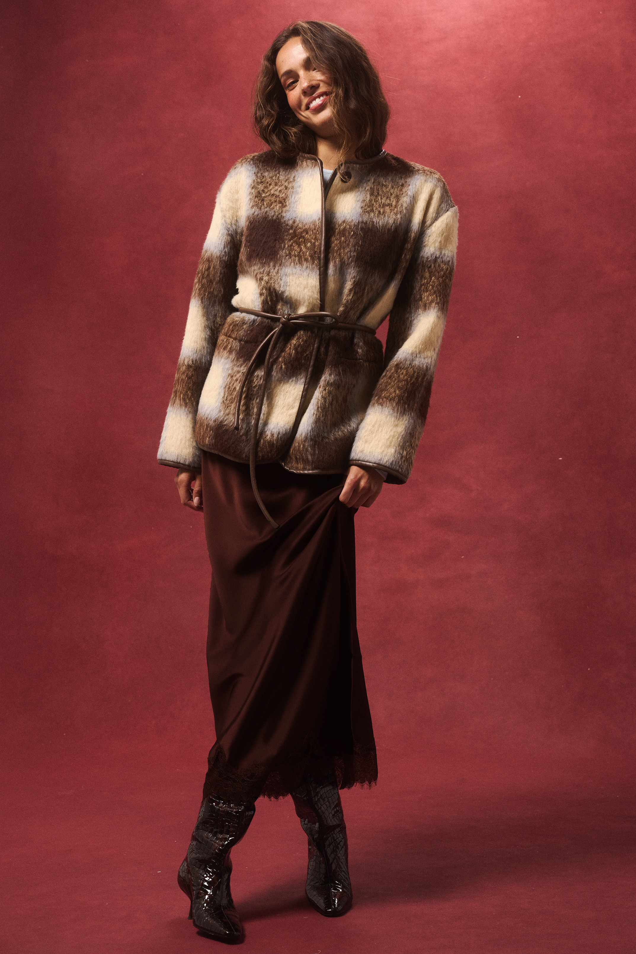 Front view of Luka Jacket showing check pattern faux fur texture with brown leather belt tie
