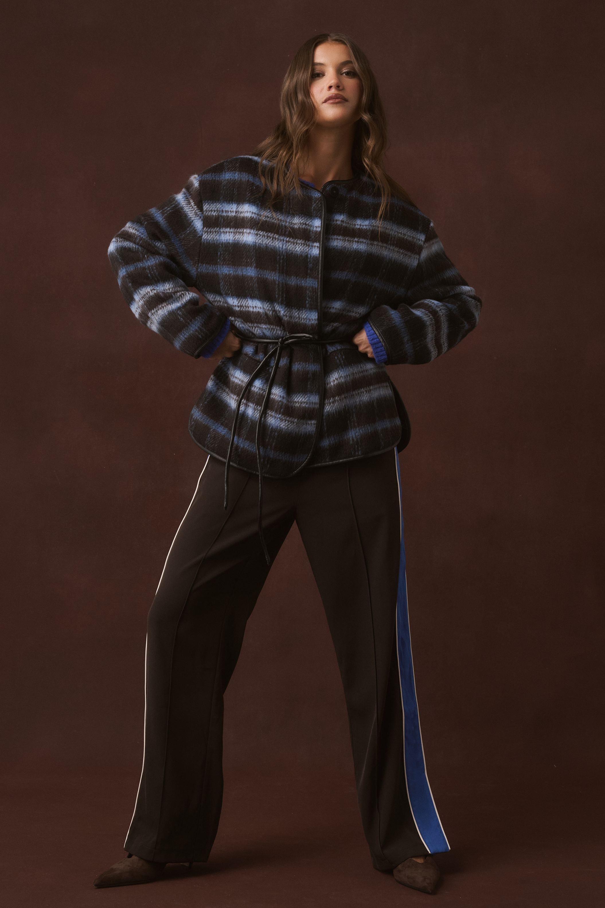 Full-length front view of a blue and brown check belted jacket with leather trim and fluffy cuffs