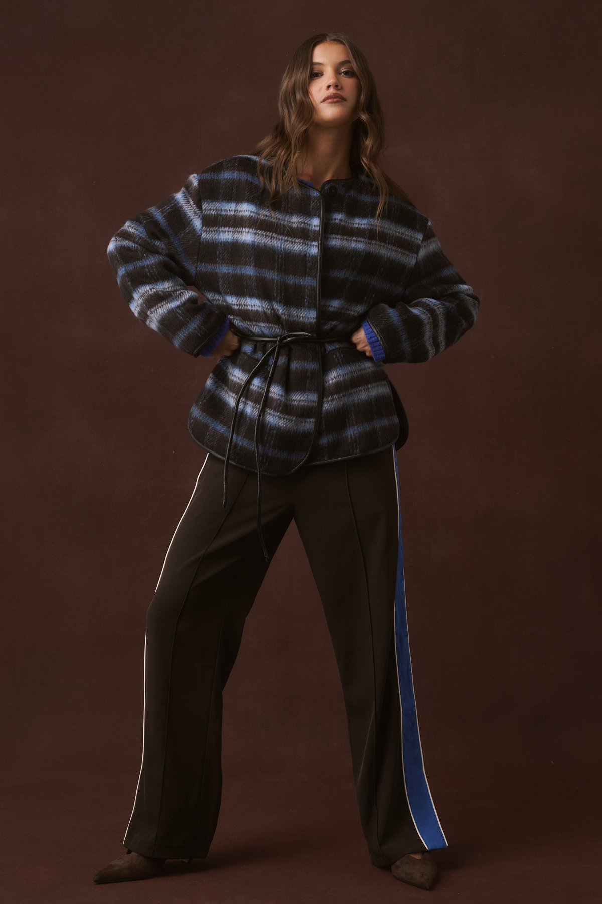 Full-length front view of a blue and brown check belted jacket with leather trim and fluffy cuffs