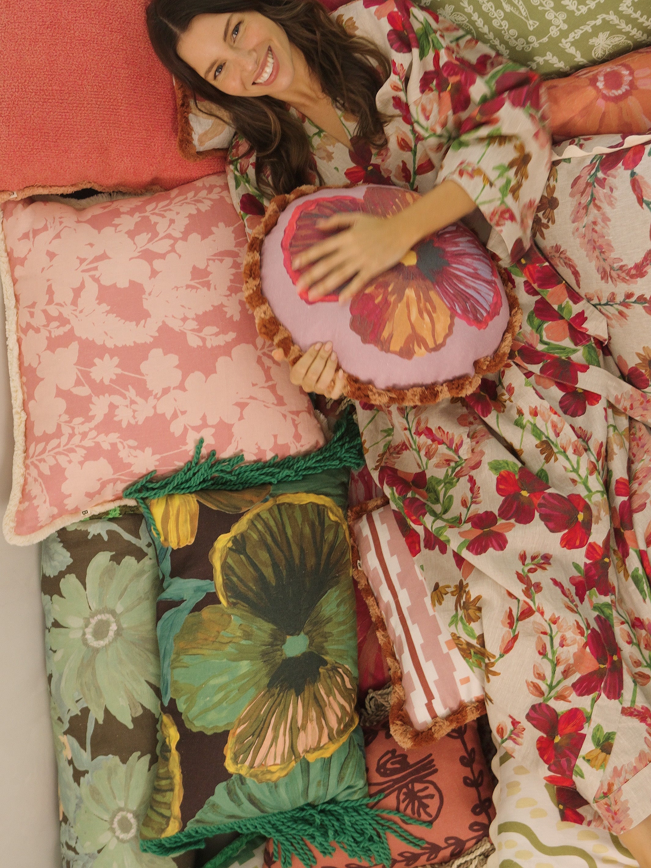 Model wearing Lupin Multi Linen Robe with floral pattern while relaxing in bed with decorative pillows