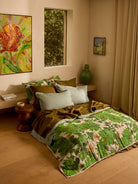 Lupin Multi & Marigold Leaf linen quilted throw draped on bed with green leaf and floral botanical print