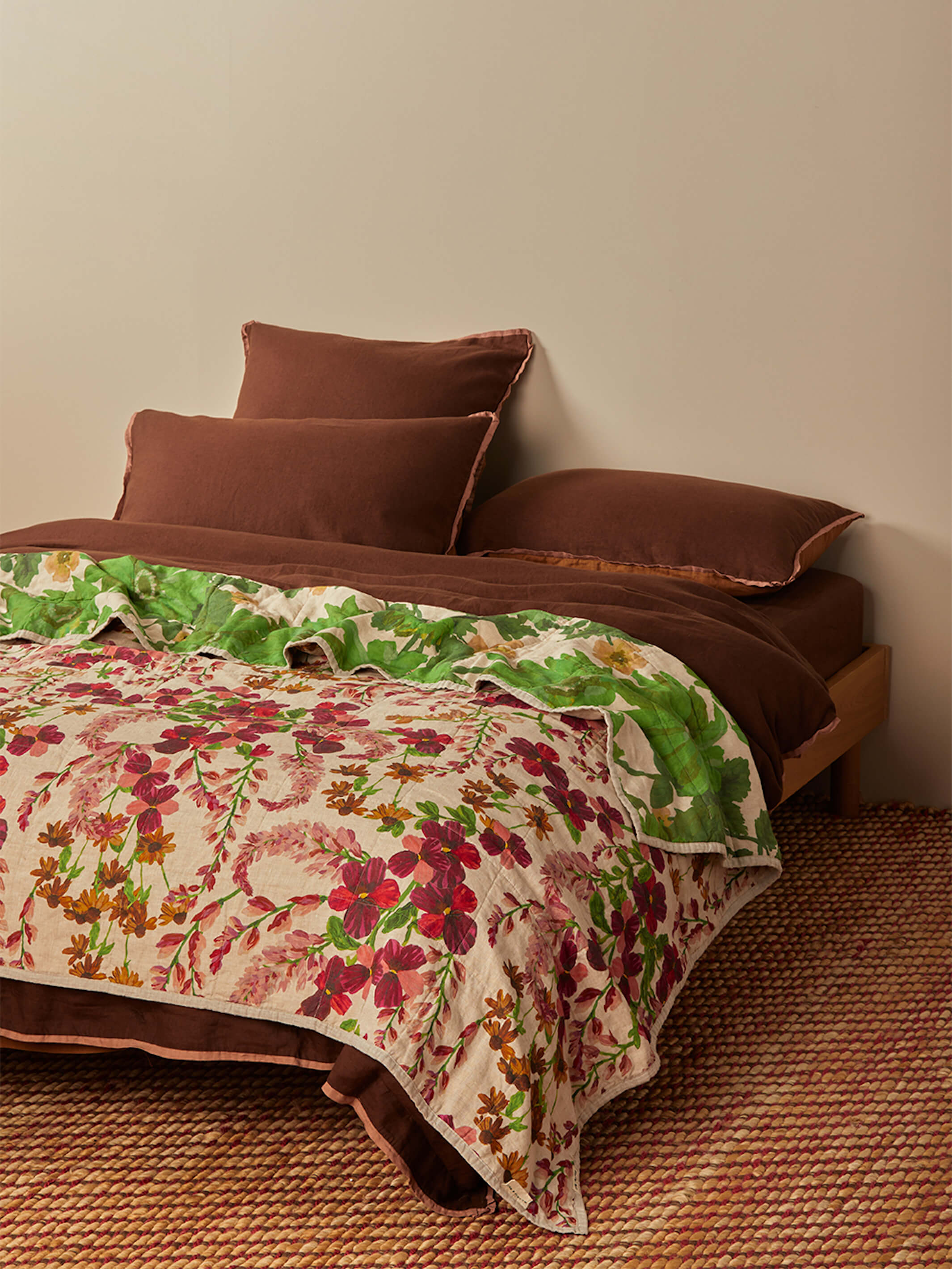 Side view of Lupin Multi linen quilted throw showing green leaf pattern and marigold floral reverse side