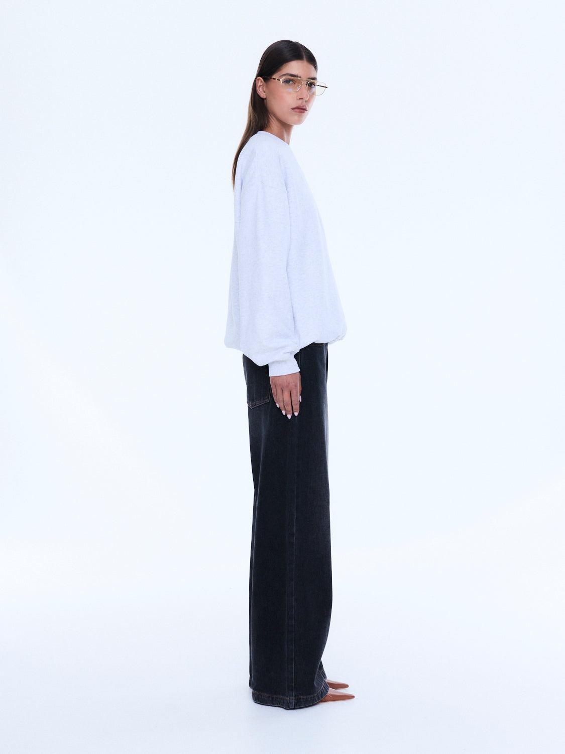 Side profile view of white Mila Oversized Sweater showing relaxed silhouette and long sleeves