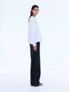 Side profile view of white Mila Oversized Sweater showing relaxed silhouette and long sleeves