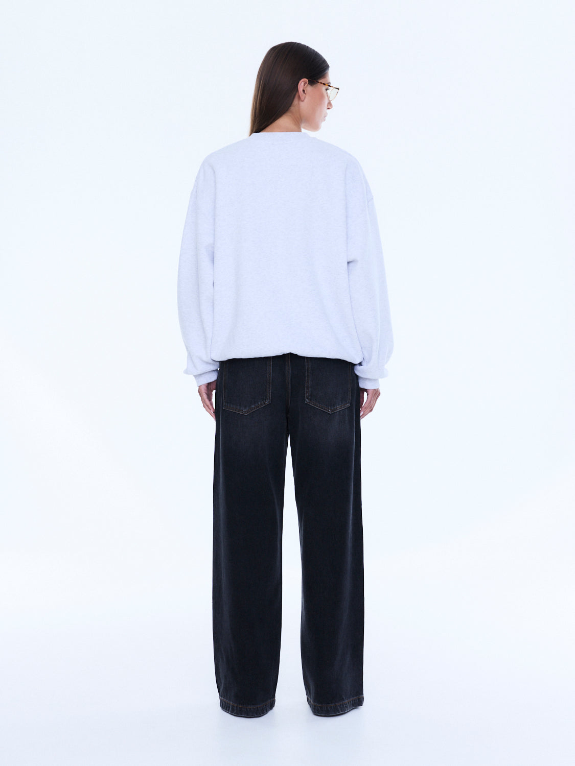 Back view of white oversized sweater showing plain back design and loose fit