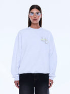 Front view of white Mila Oversized Sweater with embroidered logo and crew neckline