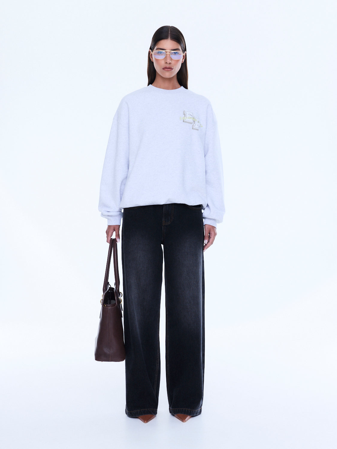 Front view of white Mila Oversized Sweater displaying loose fit and embroidered logo