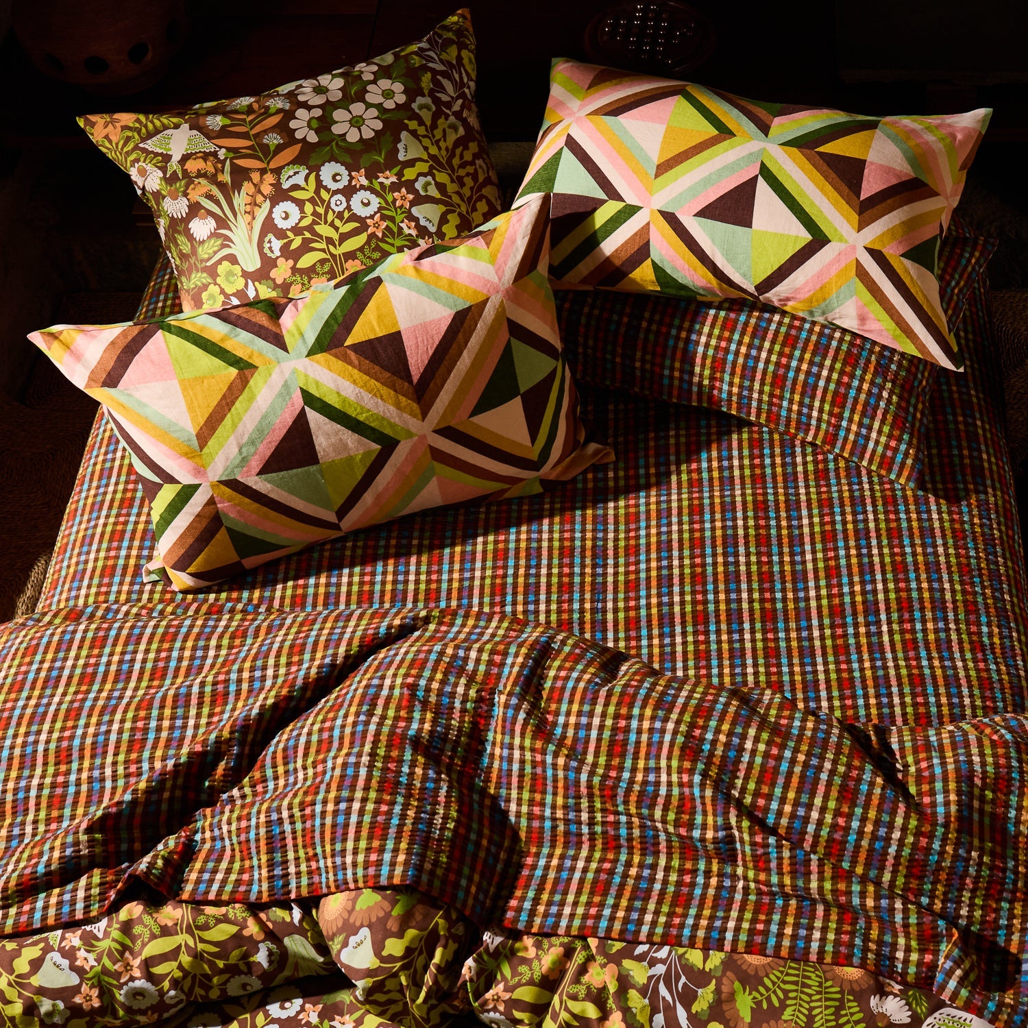 Pair of geometric triangle print linen pillowcases styled on a boho bed with mixed patterned bedding