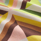Close-up of linen fabric showing multicolour geometric triangle print in yellow, green, brown and pink