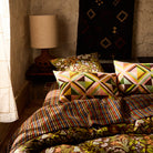 Geometric triangle print linen pillowcases on a styled bed in a warm boho bedroom setting