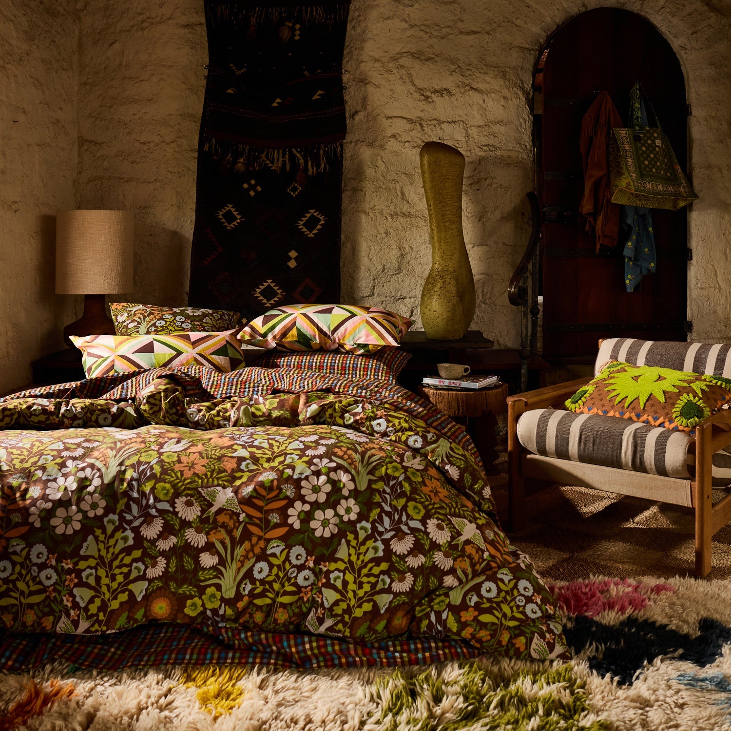 Geometric triangle print linen pillowcases on a fully styled boho bedroom bed with floral duvet