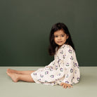 Side view of girl wearing the Mabel Dress - Winter Berry Natural Print | Nature Baby
