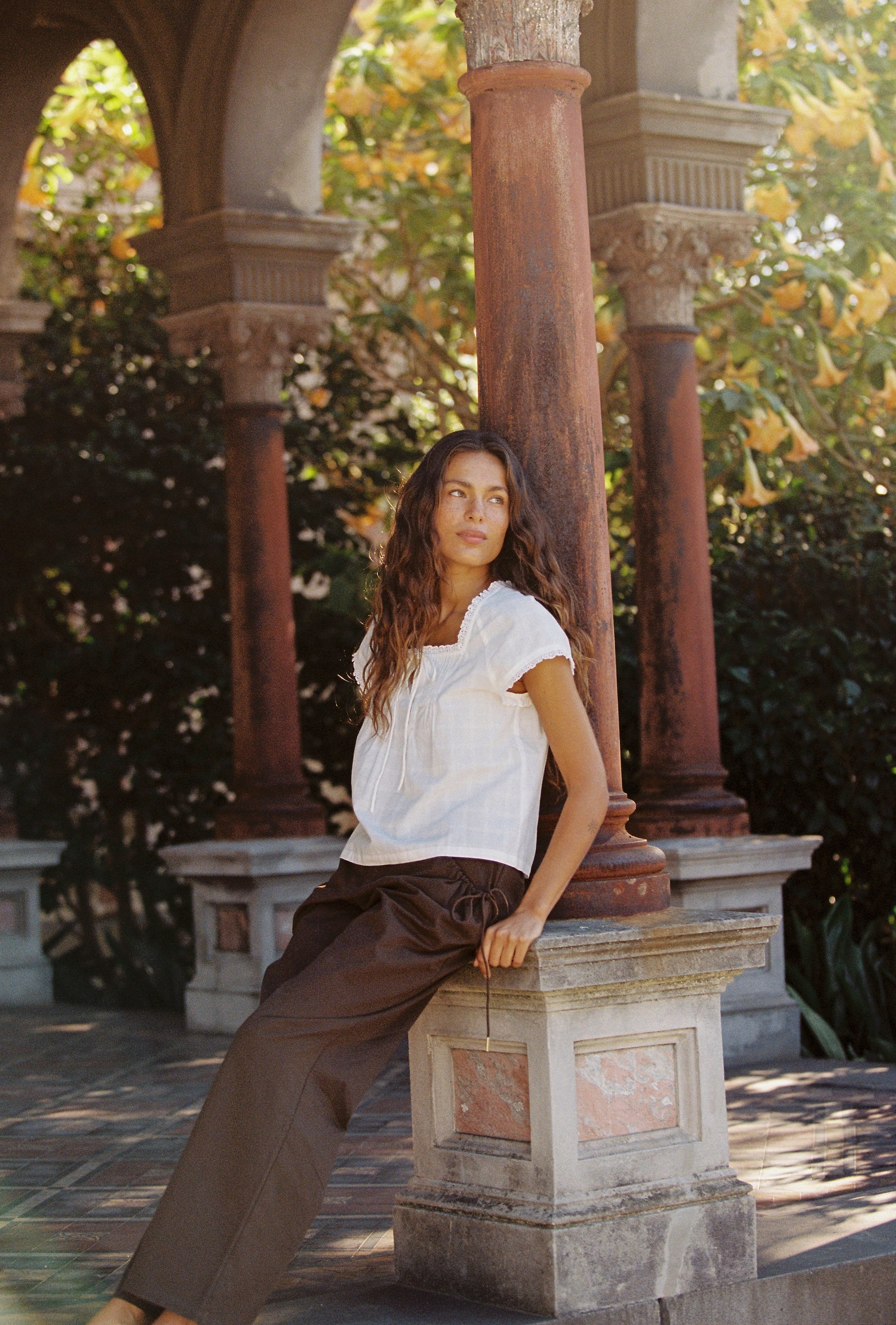 Lady wearing Juni Cotton pants with elasticated waistband and functional pockets in brown colour